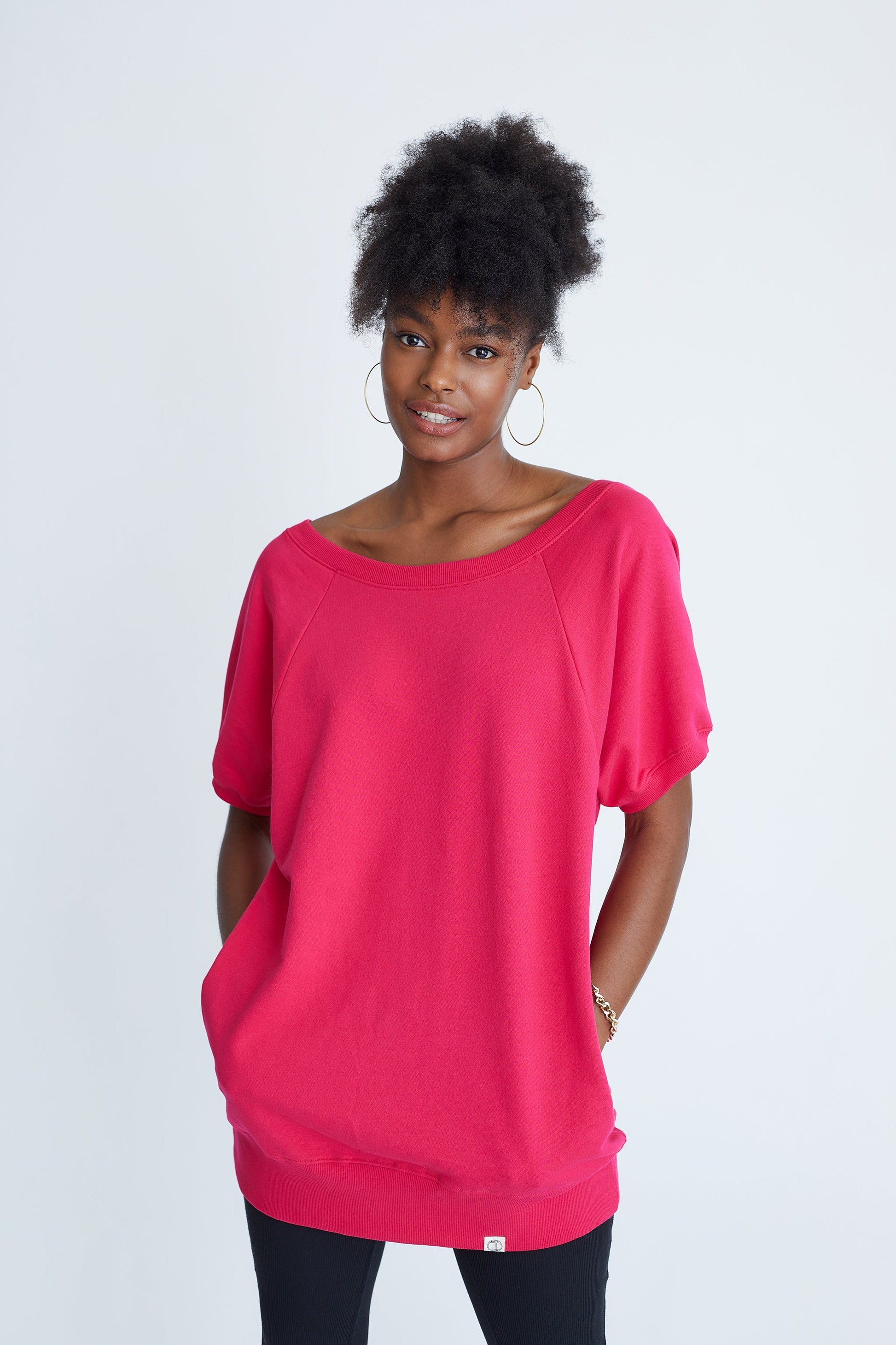 Woman wearing a bright pink top against a white background
